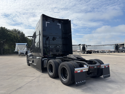 Volvo VNL64T860 truck rear view showing SLEEPER cab and twin rear axles with exposed wiring harnesses.
