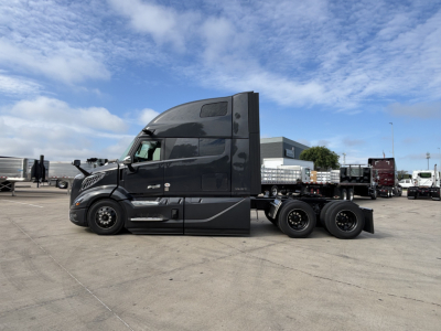 Volvo VNL64T860 truck side view showing sleeper cab and chassis with dual rear axles.
