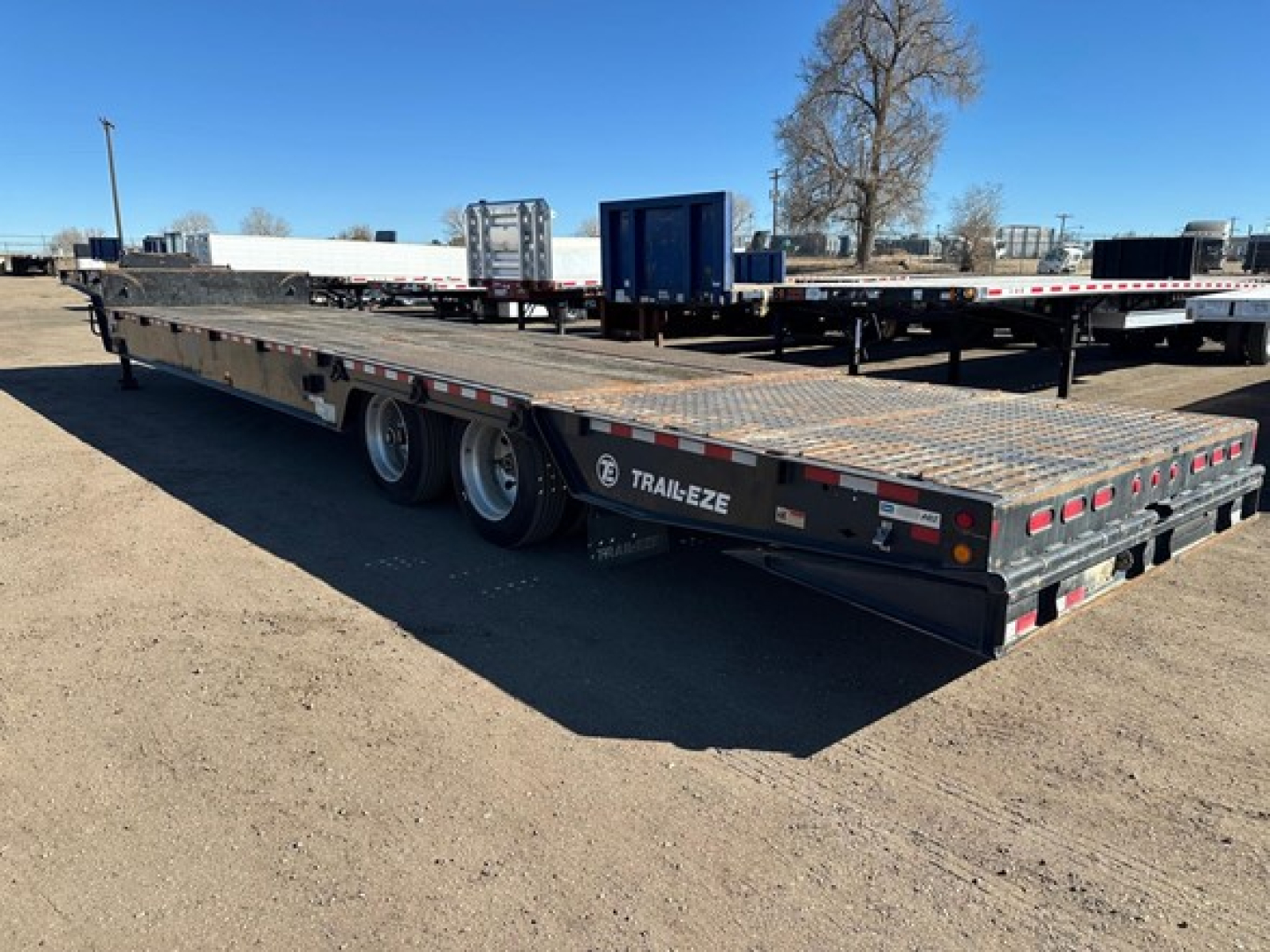Trail-Eze 40-ton hydraulic tail trailer with air ride and winch, upper deck, 3-axle configuration, black with 'Trail-Eze' branding, loading deck visible.
