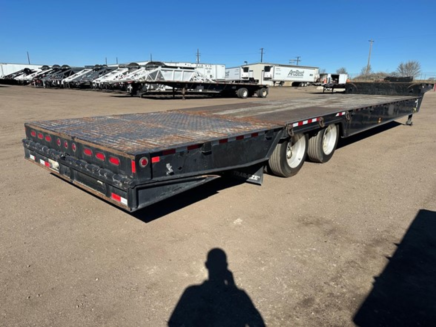 Trailer deck of a 40-ton hydraulic tail trailer with air ride, winch, and upper deck; long flatbed with dual rear axles visible.