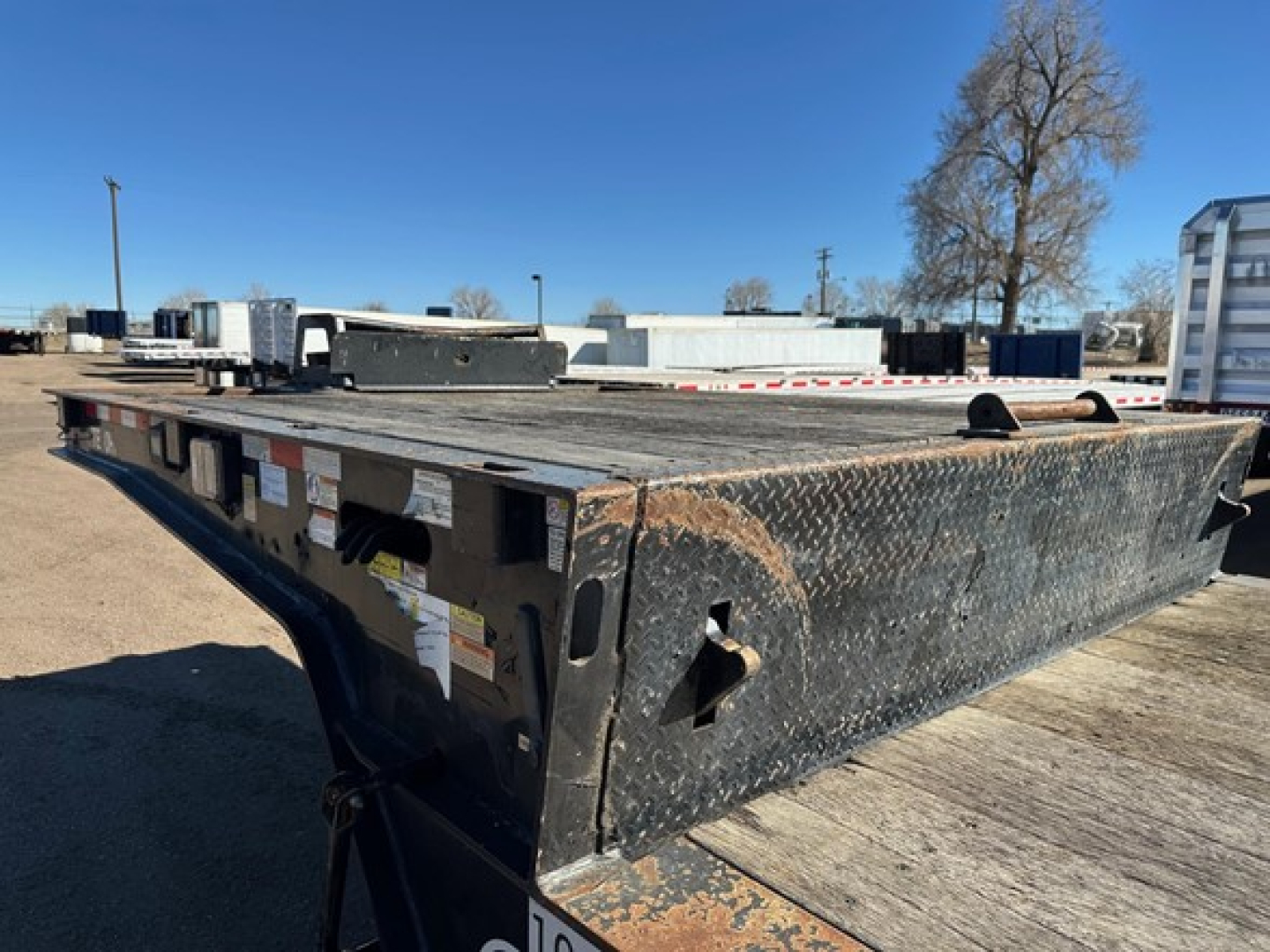 Trailer: 2021 Trail-Eze 40TON hydraulic tail with air ride and winch, upper deck, side view of front section showing diamond plate steel and mounting hardware.
