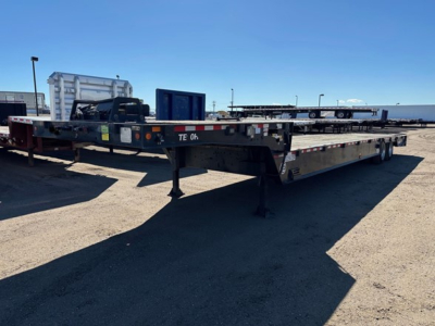 Trailer: Trail-Eze 40-ton hydraulic tail, air ride, winch, upper deck in a used trailer yard. Long flatbed with hydraulic landing, landing gear visible, VIN tag exposed.