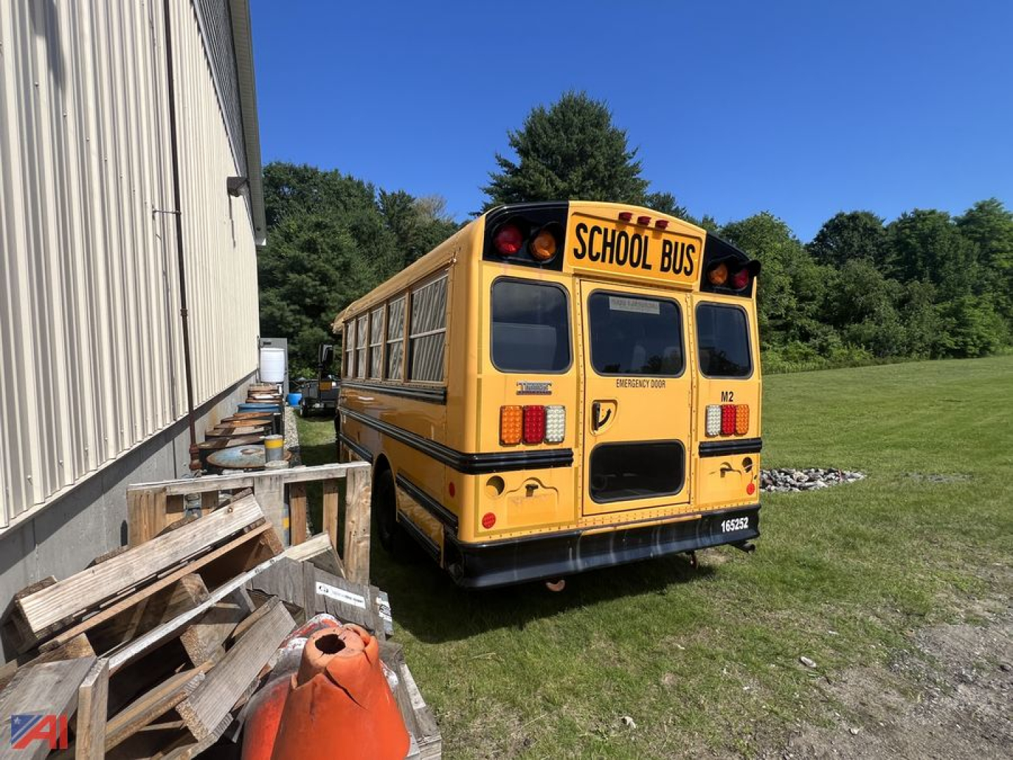 Yellow school bus rear view showing SCHOOL BUS sign and rear doors, with side windows and rear bumper.