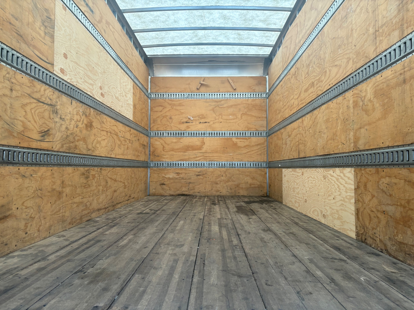 Kenworth T270 cargo truck box interior showing wooden walls and metal tie rails along the sides.