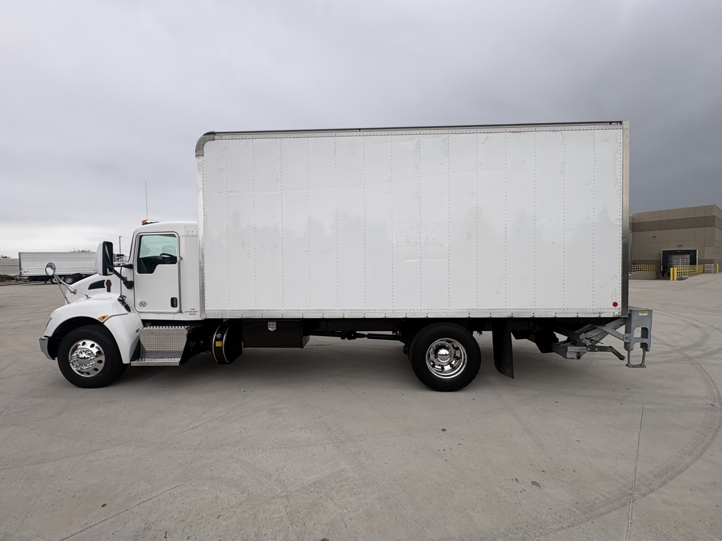 Box truck side view showing 2022 Kenworth T270 with white box body and cab, VIN 2NKHHM6X0NM486230, stock 0632206.