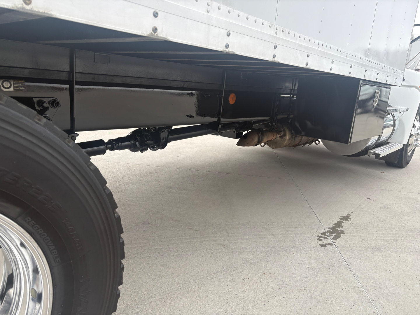 Kenworth T270 truck undercarriage showing drive shaft and rear axle with black undercarriage and trailer box