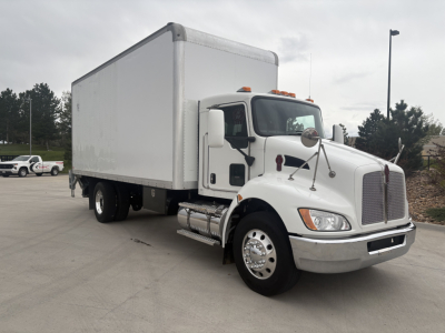 Kenworth T270 box truck in-service showing cab area and cargo box with dual rear wheels and chrome exhaust; windshield wipers and side mirrors visible.