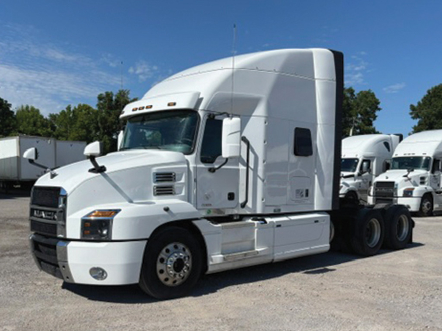 Truck cab in a used 2022 Mack Anthem listing showing a white sleeper tractor with aerodynamic cab and multiple axles.