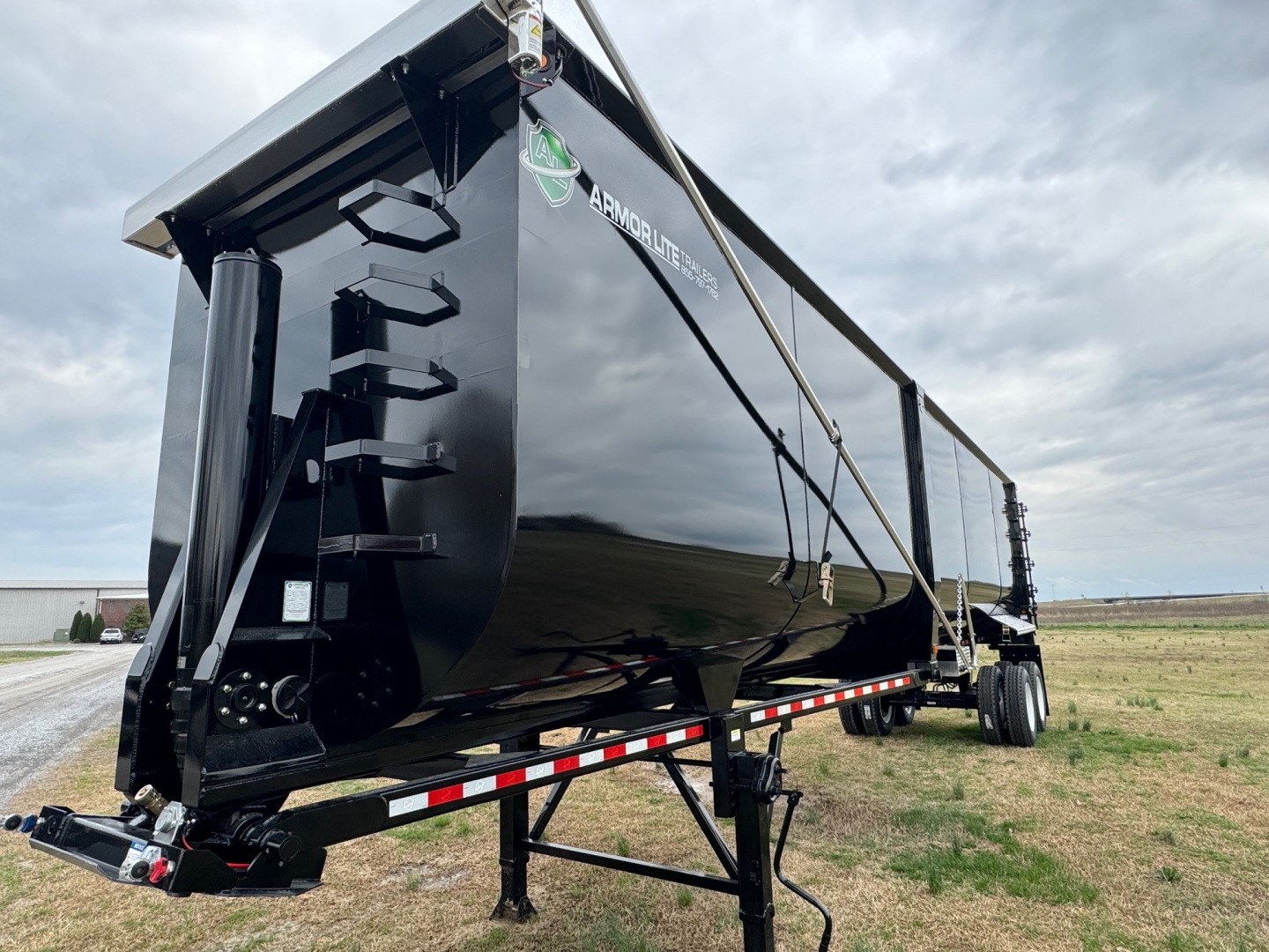 Armor Lite dump trailer showing side view with reflective black paint and equipment cradle, 40' length and heavy-duty frame.