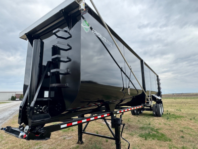 Armor Lite dump trailer showing side view with reflective black paint and equipment cradle, 40' length and heavy-duty frame.