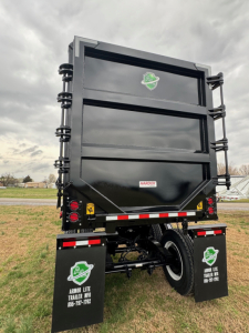 Dump trailer back view showing Armor Lite branding, black steel body, dual rear mud flaps, side support springs, and reflective tape.