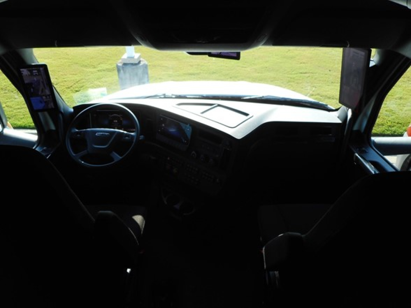 Cab interior of a Freightliner Cascadia 126 truck viewed from passenger seat, dashboard and steering wheel visible.