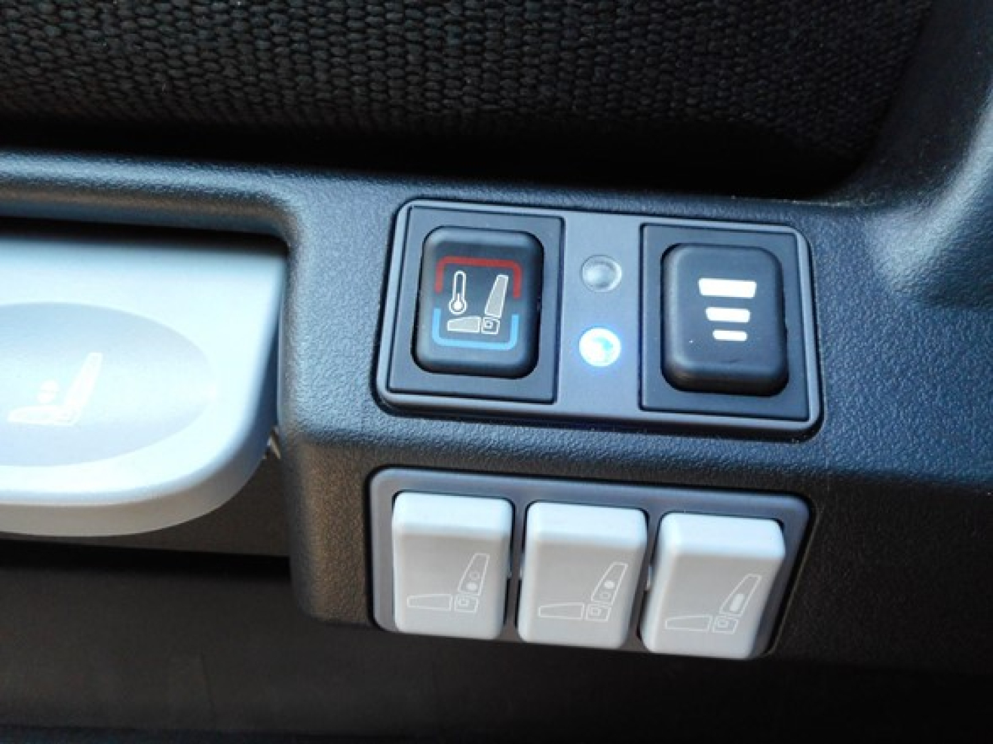 Freightliner Cascadia 126 dash area showing seat heater/controls and three white window/seat icons switches.