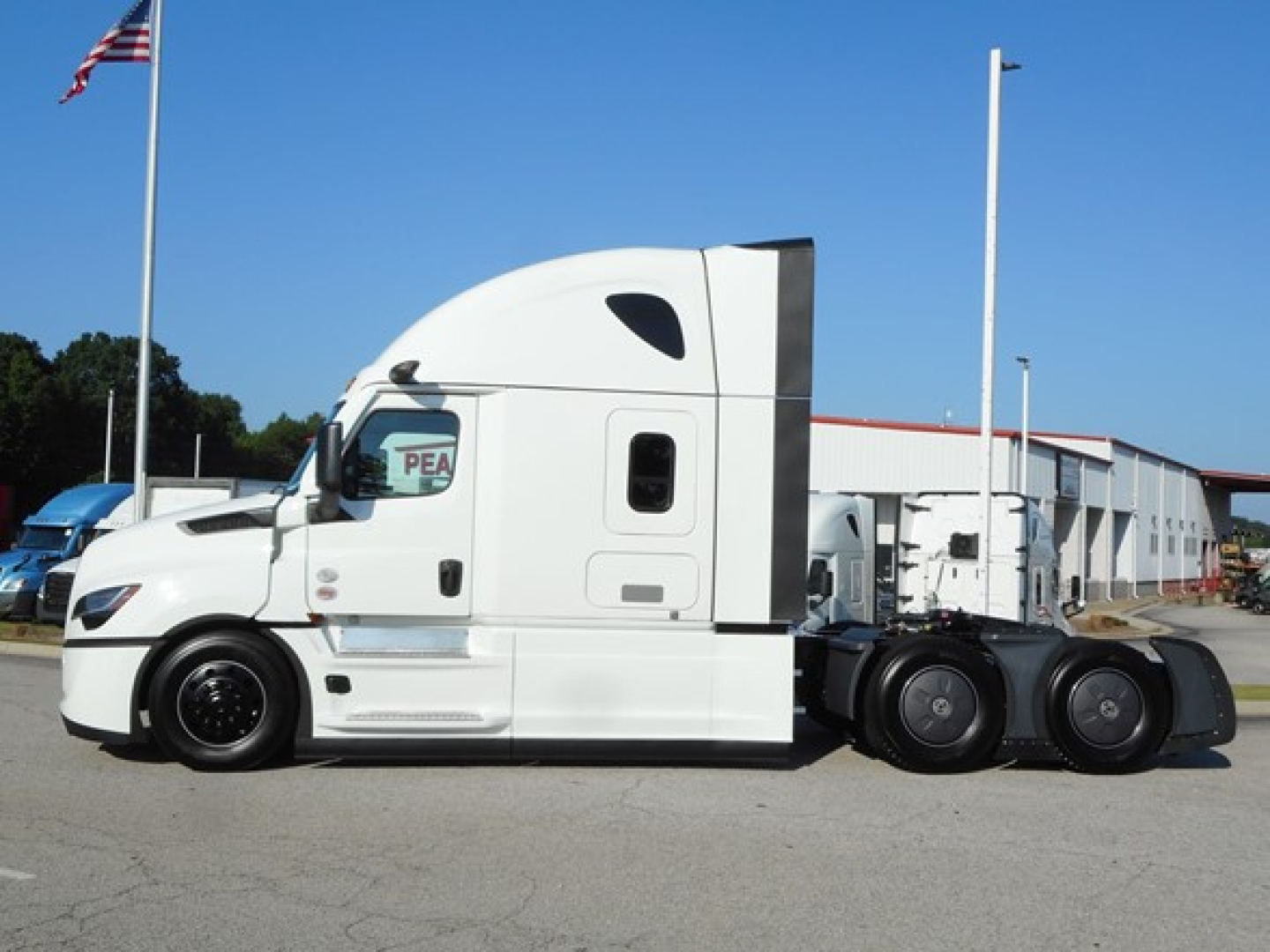 Freightliner Cascadia 126 tractor-trailer side profile showing white cab with sleeper, black wheels, and fifth-wheel/mid-axle chassis.