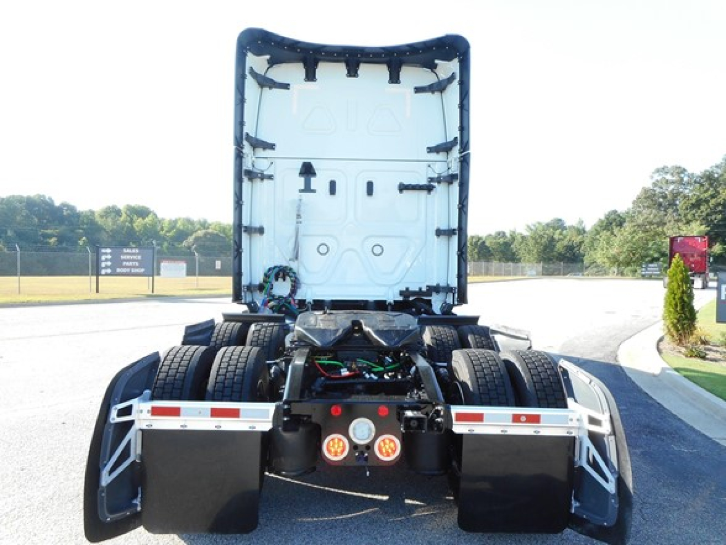 Freightliner Cascadia 126 truck rear view with open sleeper cab, showing chassis and dual rear axles.