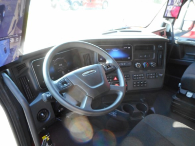 Freightliner Cascadia 126 truck dashboard view with steering wheel, touchscreen display, and control panel in cabin.