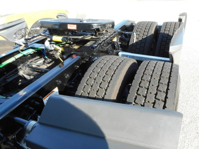 Truck chassis view showing dual rear axles and drive tires of a Freightliner Cascadia 126 cabless frame with visible frame rails and air lines.