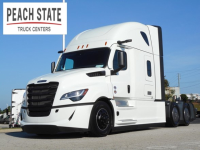 Freightliner Cascadia truck side view showing white tractor with sleeper cab and Peach State Truck Centers logo in foreground.