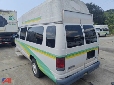 Ford E-350 van with a raised roof cap, green and yellow diagonal stripe graphics on white body, rear doors, windows along sides.