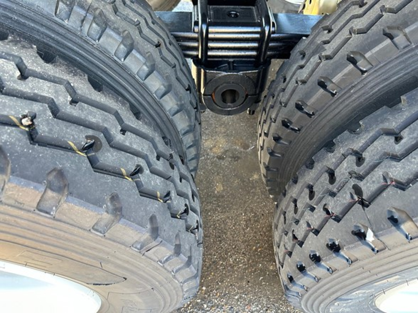 Rear view of 2026 Dura Haul Rock Tub Frameless End Dump trailer showing dual heavy-duty tires, axle area, and suspension components.