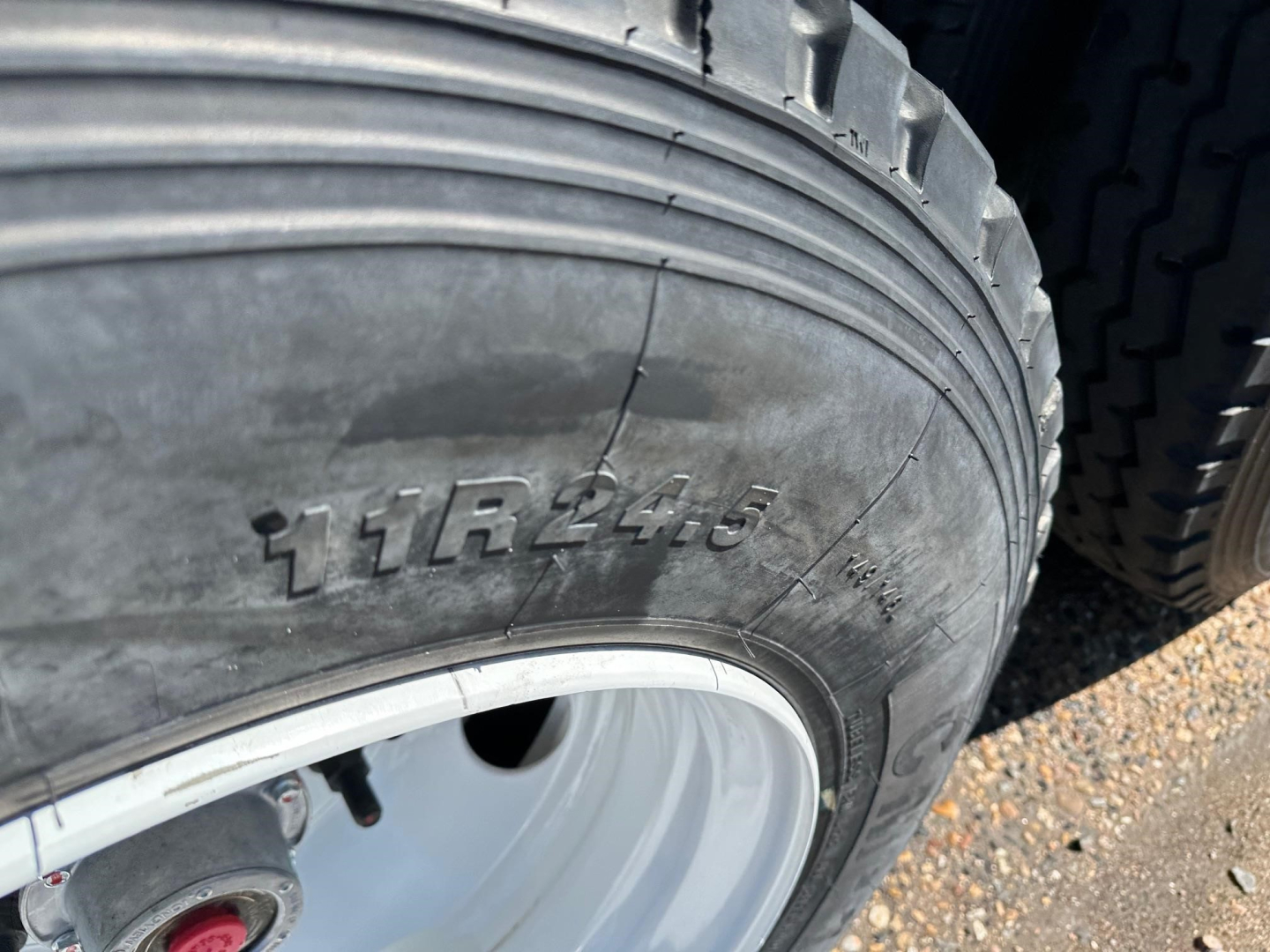 Tire and wheel close-up showing 11R24.5 tire size on trailer wheel.