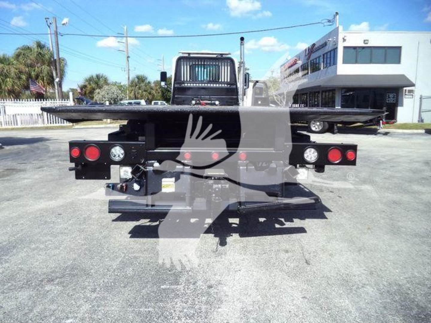Flatbed rollback truck rear view showing rear loading platform and taillight clusters on a 2016 Peterbilt 567.