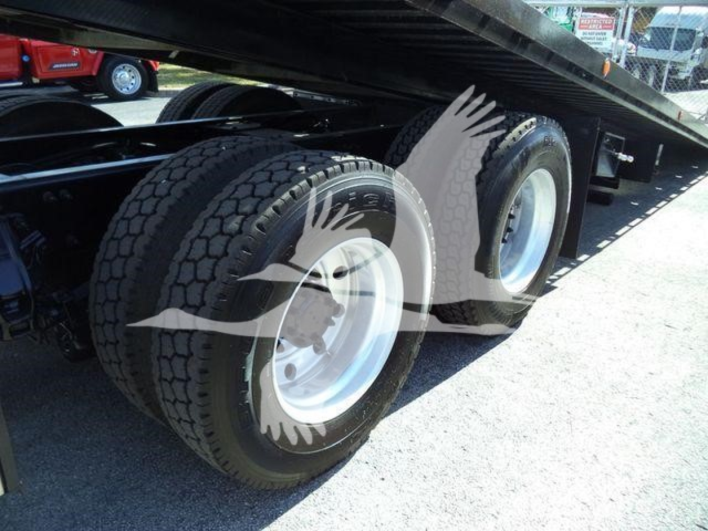 Truck rear wheels of a 2016 Peterbilt 567 rollback showing dual tandem axle with tires and rims under elevated trailer.