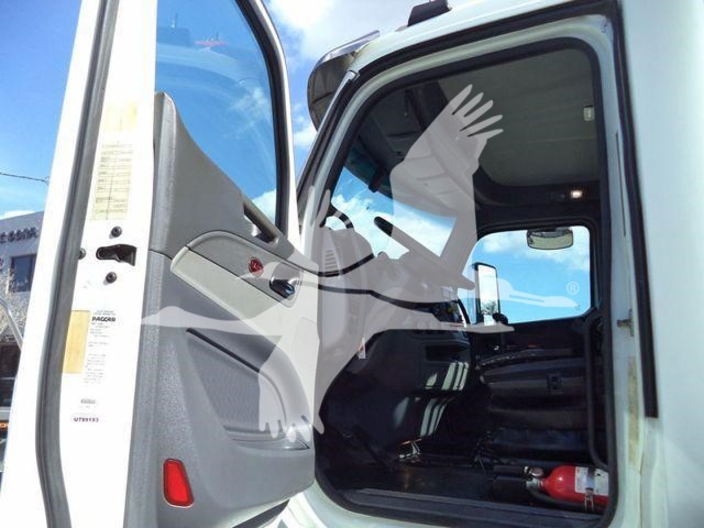 Truck cab interior of a 2016 Peterbilt 567 with open door and visible steering area.