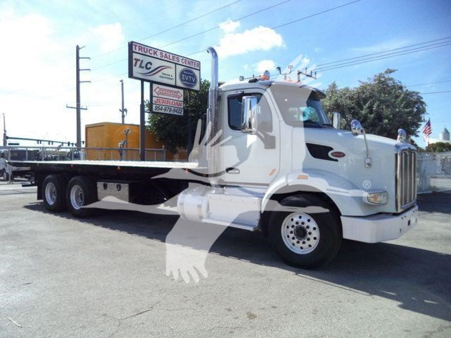 Peterbilt 567 highway truck side view showing flatbed rollback with white cab and chassis.