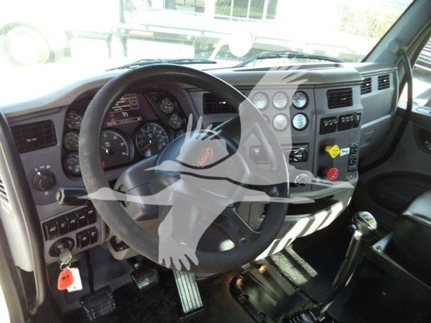 Peterbilt 567 truck interior showing steering wheel and dashboard with gauges and controls.