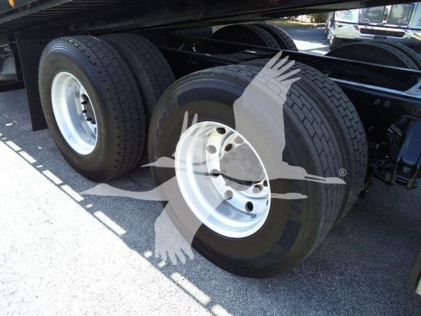 Dual rear wheels (dual tires) on a Peterbilt truck with white rims and black tires, undercarriage visible.