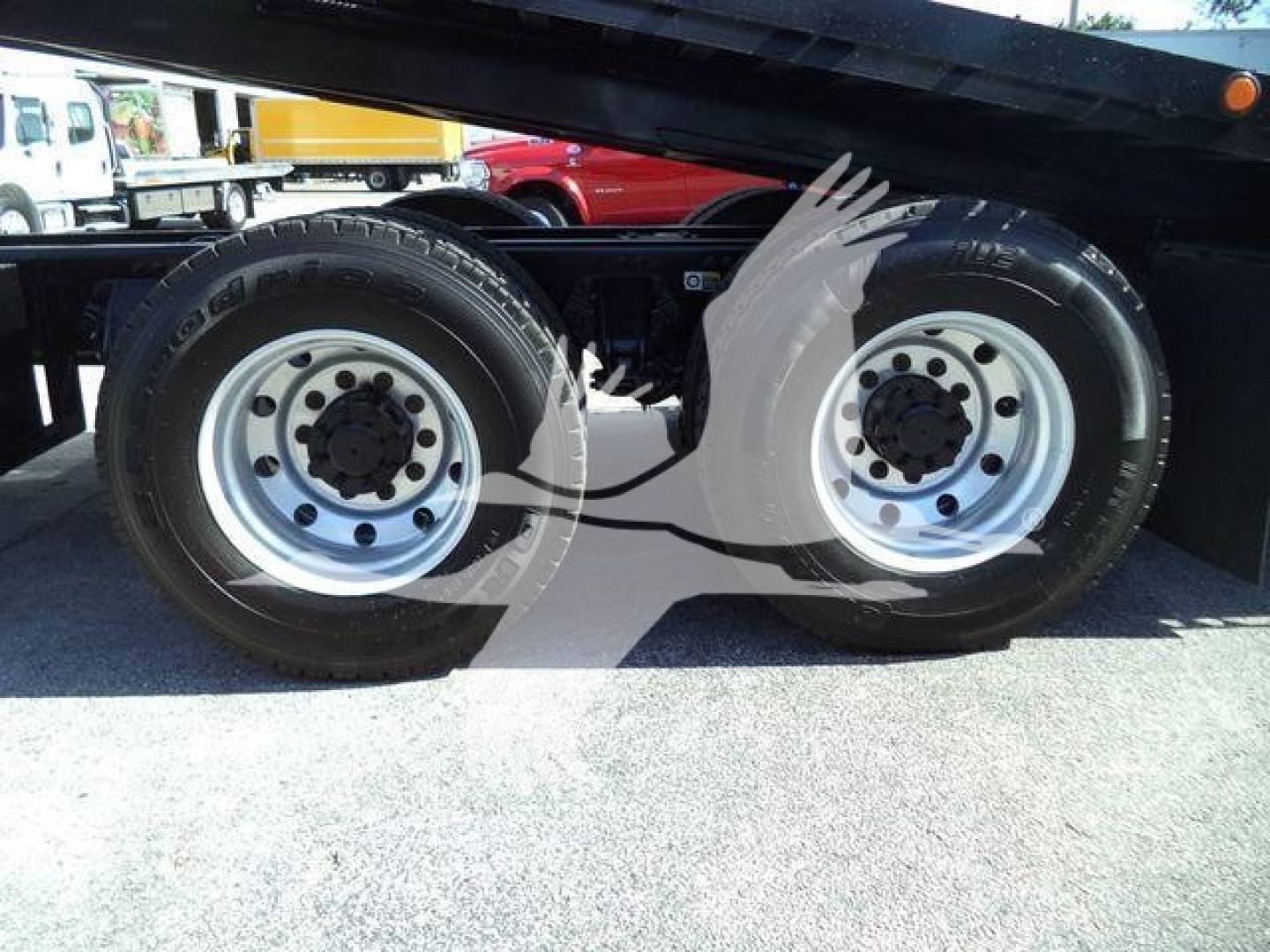Dual rear wheels of a Peterbilt 567 rollback trailer showing aluminum rims and tires