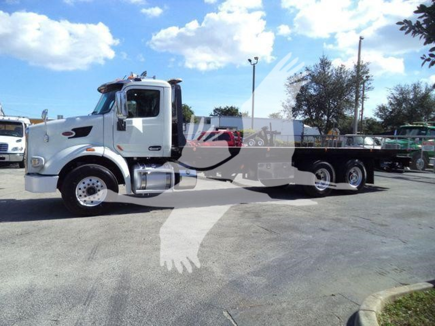 Peterbilt 567 rollback truck side view showing cab and long flatbed chassis with dual rear axles.