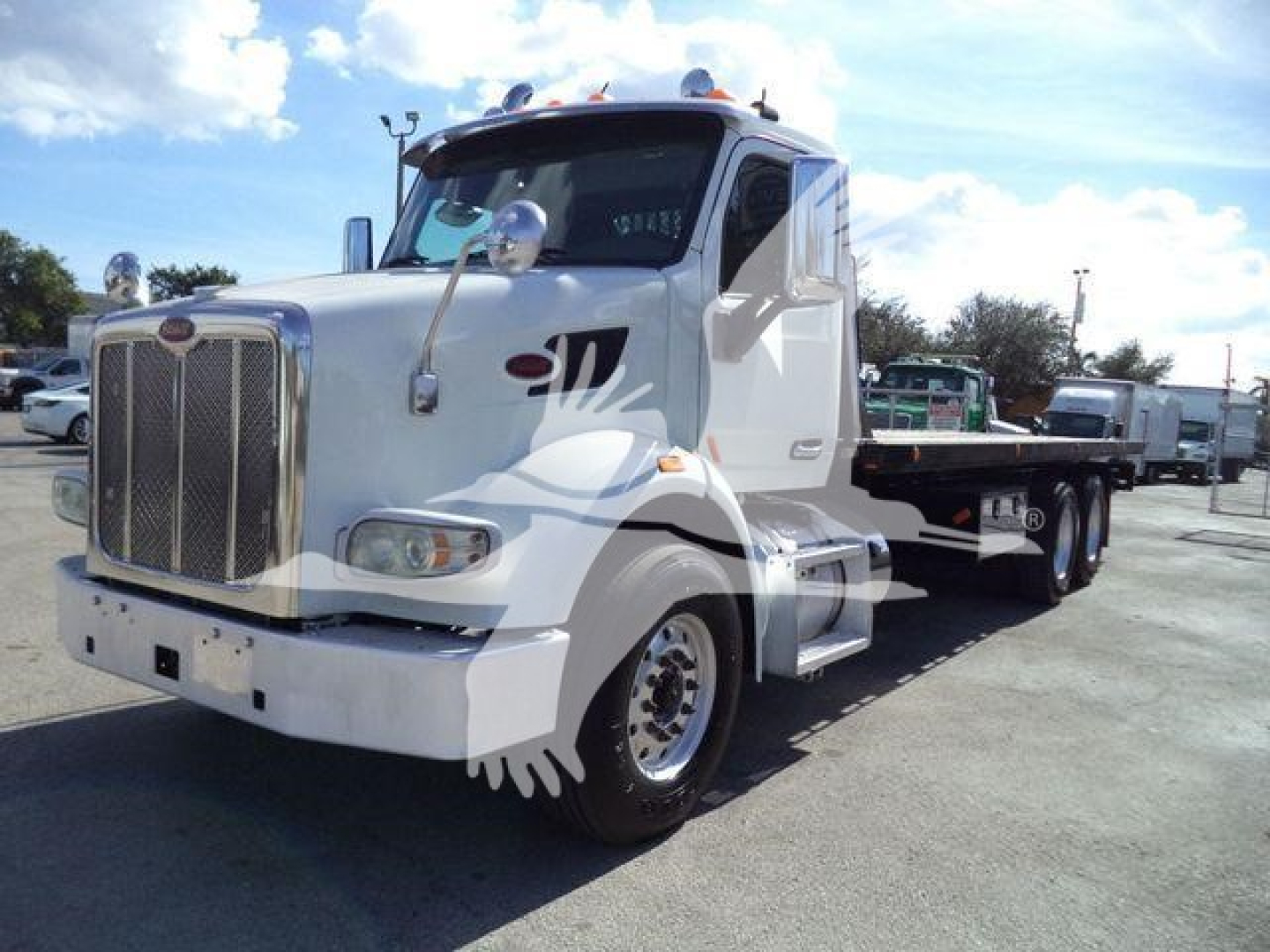 White Peterbilt 567 truck in a parking lot, front grille, side mirrors, and dual rear wheels visible.