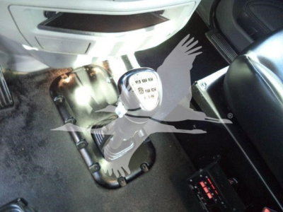 Trucks interior near gear shifter and floor, with transmission tunnel and seat visible.
