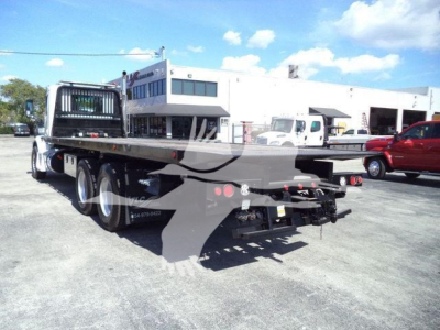 Peterbilt 567 rollback truck flatbed rear view showing dual rear axles and hitch area.