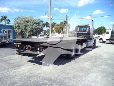 Peterbilt 567 rollback truck flatbed showing rear and chassis with tow hitch and dual rear wheels.