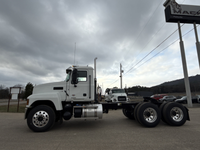 Truck side view of a 2026 Mack PI64T conventional daycab showing truck cab, dual rear axles, fuel tanks, and empty tractor frame.