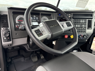 Mack PI64T truck interior showing steering wheel and gauge cluster with center console and controls.