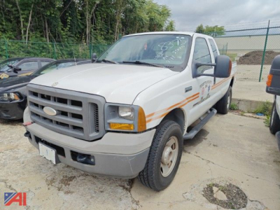 Ford F-350 pickup truck in-service front-left view showing white cab with orange side decals and gray front bumper.