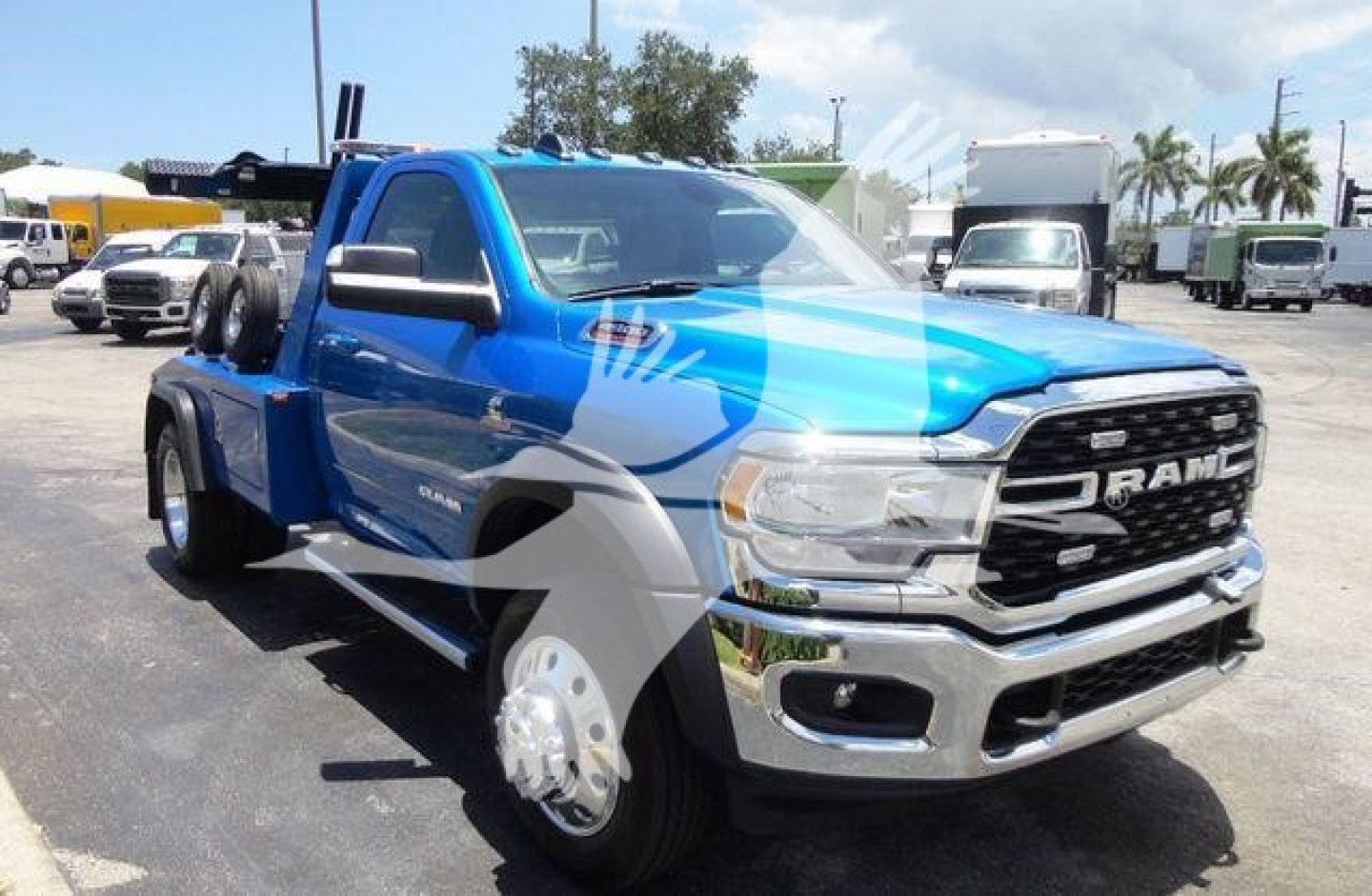 Ram 4500 pickup truck in blue and chrome showing front grille, RAM emblem, and winch setup in a dealership lot.