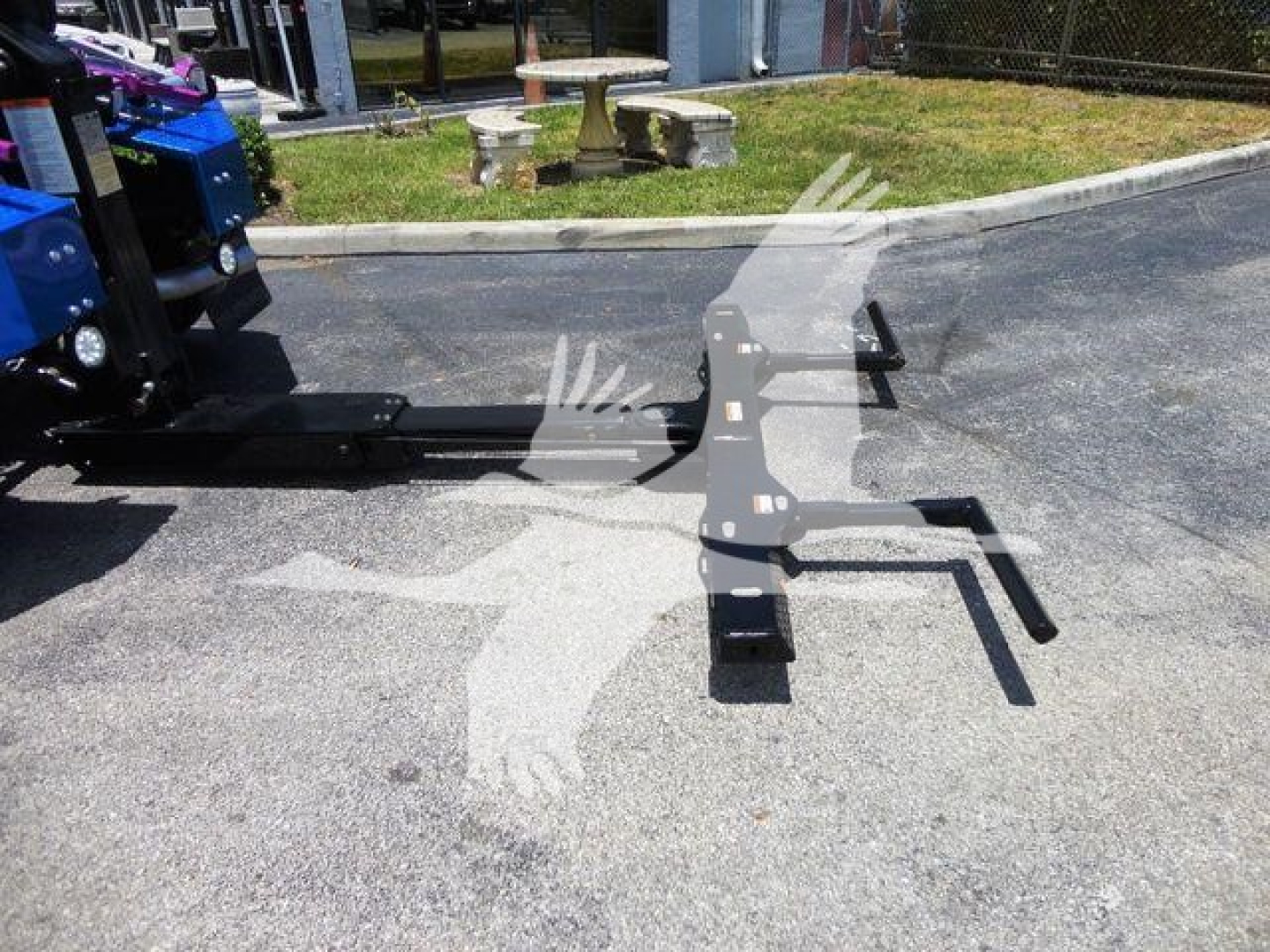 Ram 4500 SLT winch setup showing front frame and mounting brackets attached to a blue vehicle in an outdoor lot.
