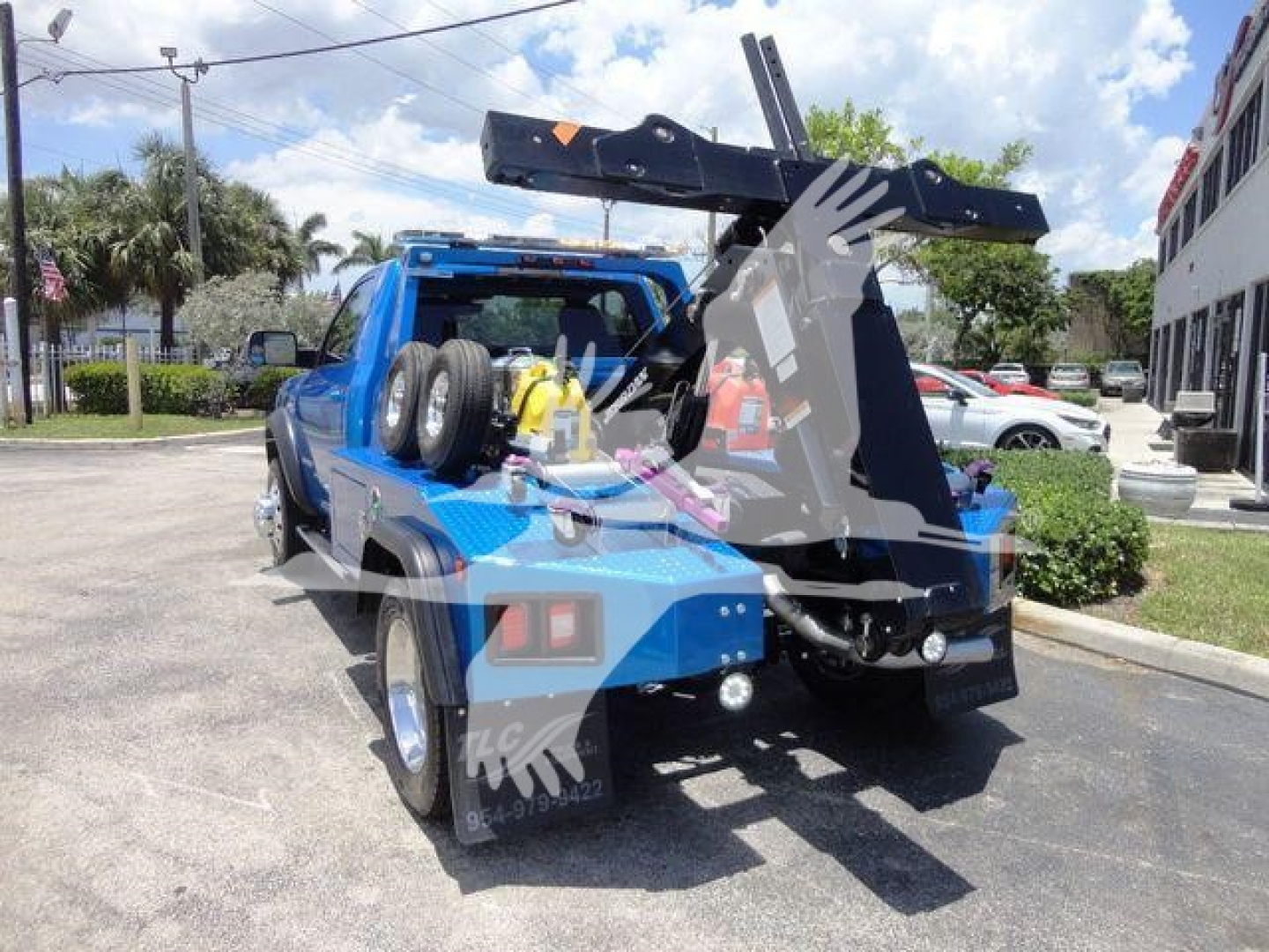 Truck bed with winch and mounted crane/boom, blue Ram 4500 SLT towing/utility configuration, rear view showing spare tires and hydraulic winch area.