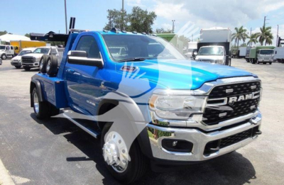 Ram 4500 pickup truck in blue and chrome showing front grille, RAM emblem, and winch setup in a dealership lot.