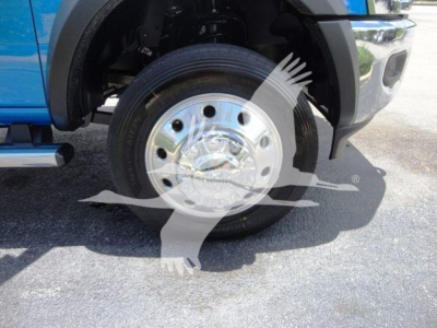 Front wheel and tire of a blue 2024 Ram 4500 SLT with chrome factory wheel and exposed braking components.