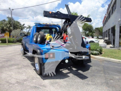 Blue Ram 4500 SLT tow truck with heavy-duty wheel lift and rear-mounted winch, visible tires and parking lot background.