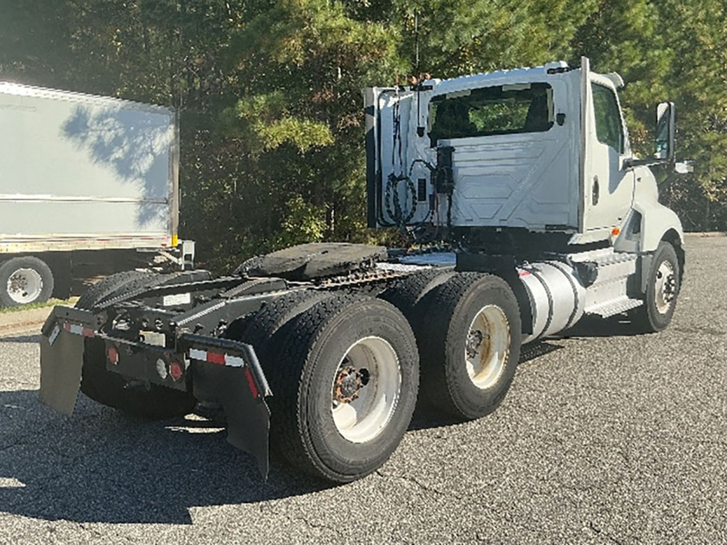 Truck rear/intermediate view of a white 2019 International LT625 conventional daycab showing the chassis and rear axles.