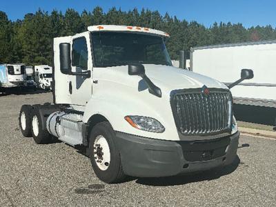 White 2019 International LT625 conventional daycab truck front-left view with large grille and dual rear axles visible in a lot.