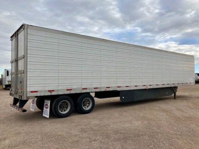 Utility reefer trailer showing side panel, rear doors, and dual rear axles.