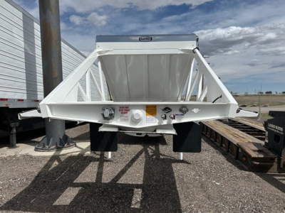 Ranco air ride bottom dump trailer viewed from rear showing white steel frame, hydraulic components, and bumper/lighting area.